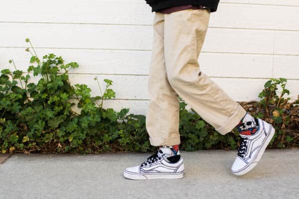 Boy in outlined Vans sneakers walking. 