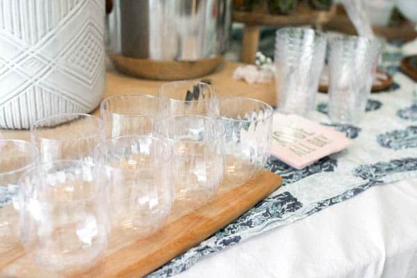 Plastic stemless wine glasses lined up on a table.