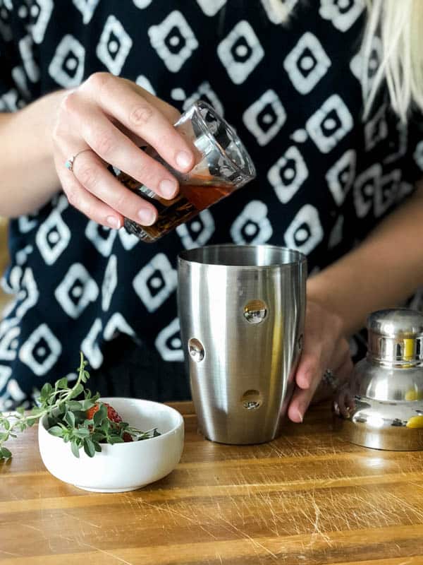 Adding scotch to a cocktail shaker.