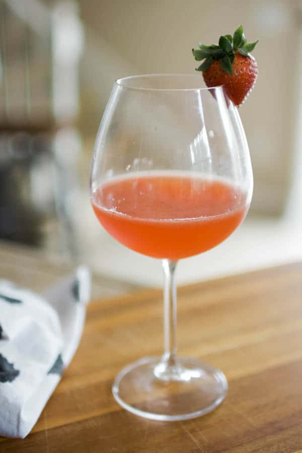 A wine glass holding a whiskey sour cocktail. 