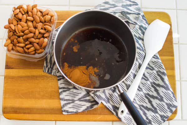 Pan on a cutting board with the mixture for making candied almonds.