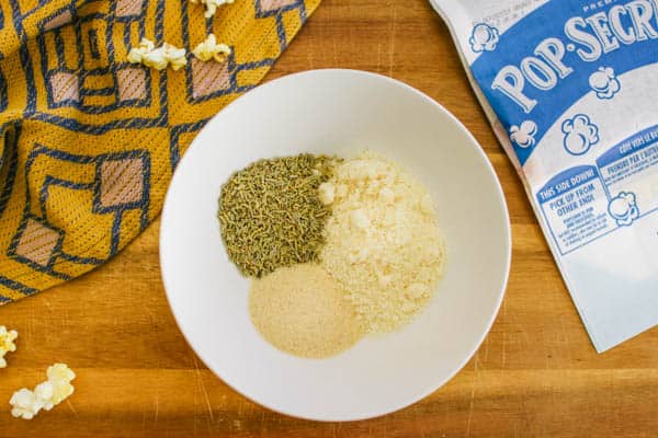 Overhead shot of a plate on a counter with spices next to a bag of unpopped popcorn. 