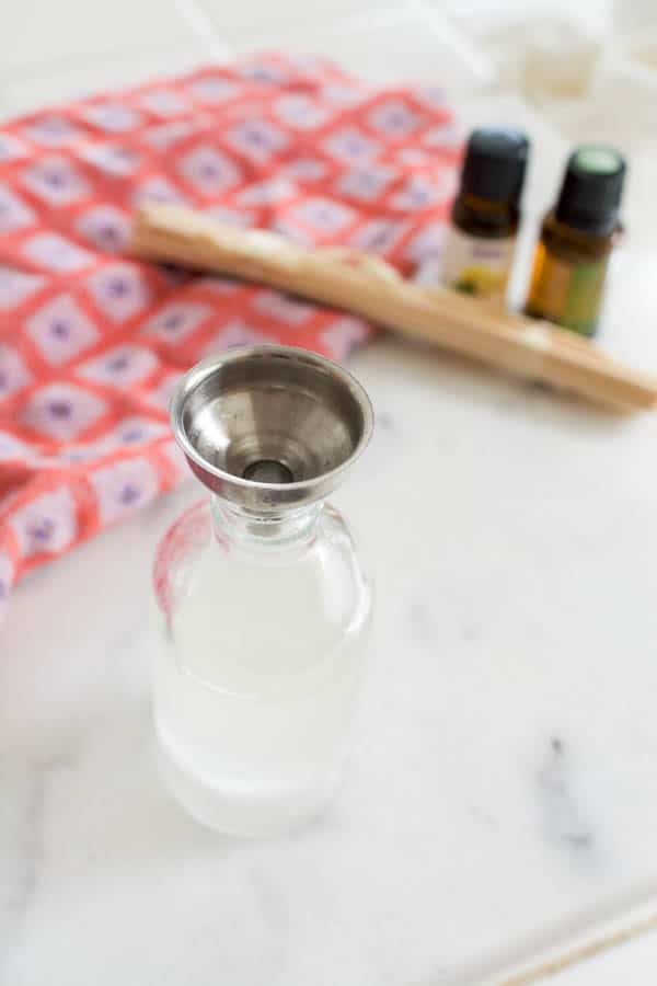 A glass bottle with a metal funnel in the top.