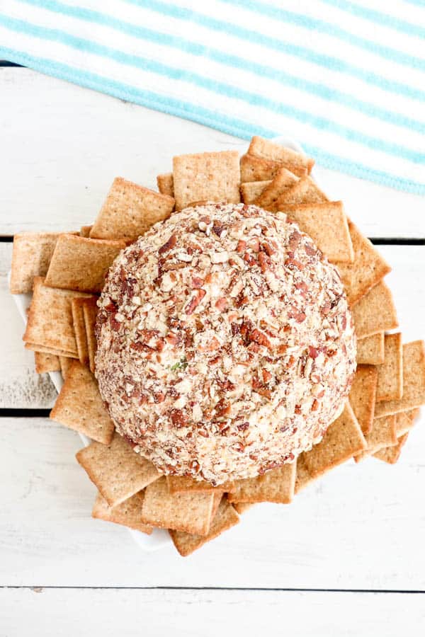 Chicken and ranch cheeseball surrounded by crackers on a white plate.