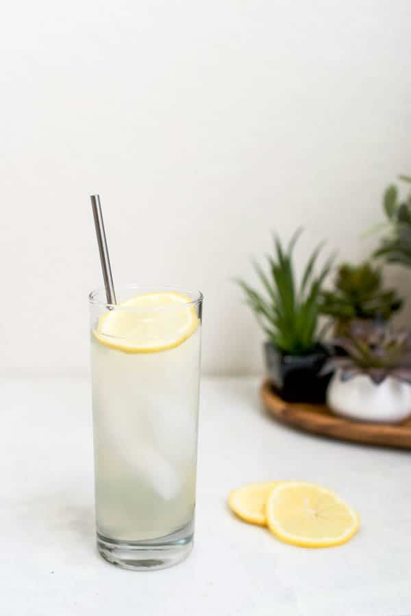 Cocktail on a table with a lemon garnish.