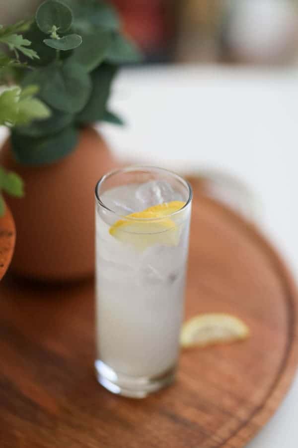 A Long Vodka cocktail sitting on a wooden tray. 