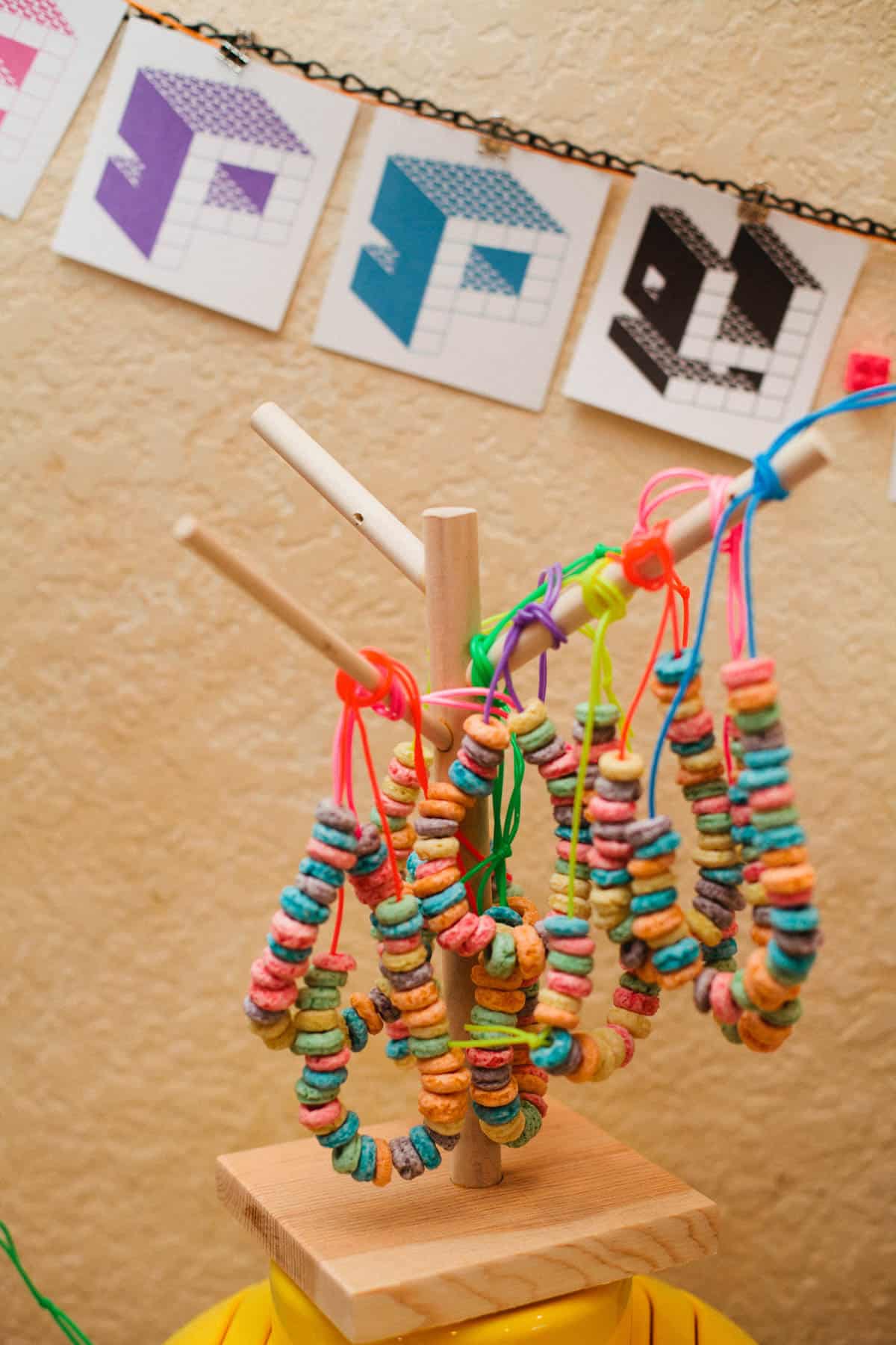 Cereal necklaces hanging on a display for a kids birthday party.