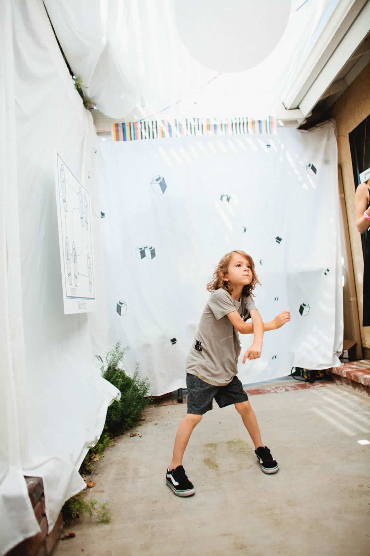 Kid dancing in a room decorated to look like a kids dance club for a lego themed birthday party.