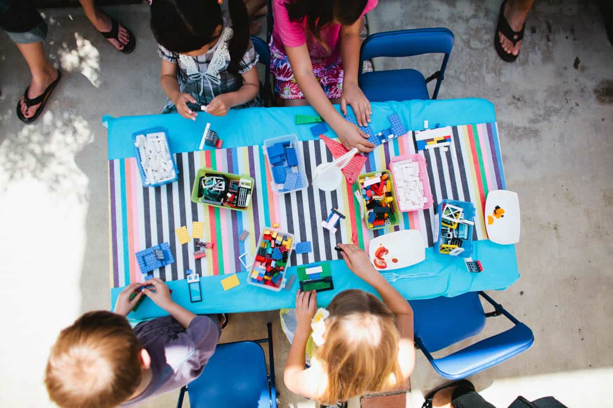 Kids making legos at a lego themed birthday party.