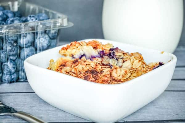 White bowl of peach and blueberry dump cake.