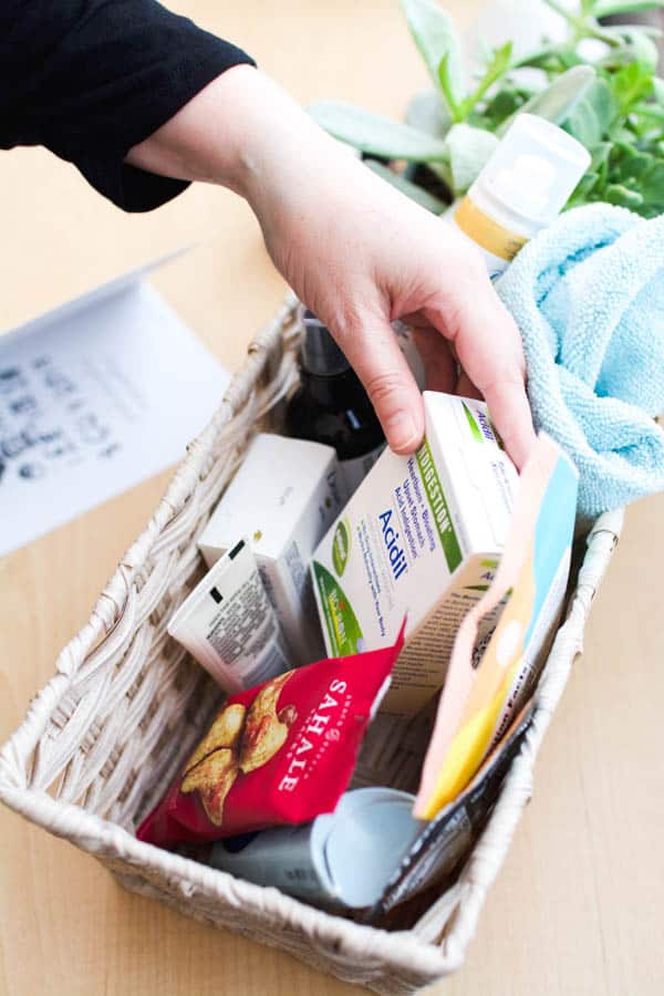 A hand reaching into a basket full of items for an overnight visitor