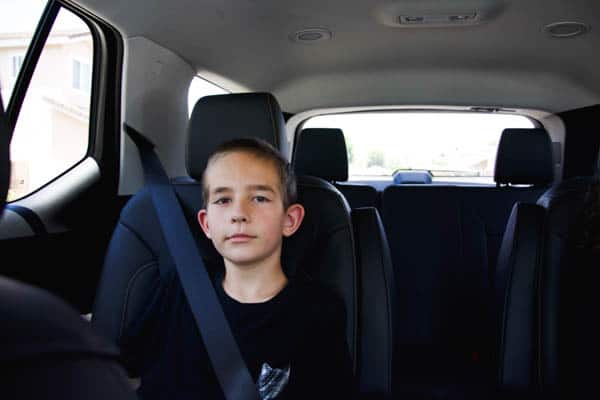 Kid sitting in the back seat of the Chevy Traverse