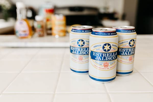 Estrella jalisco beer on the counter with ingredients for fall beer cocktail.