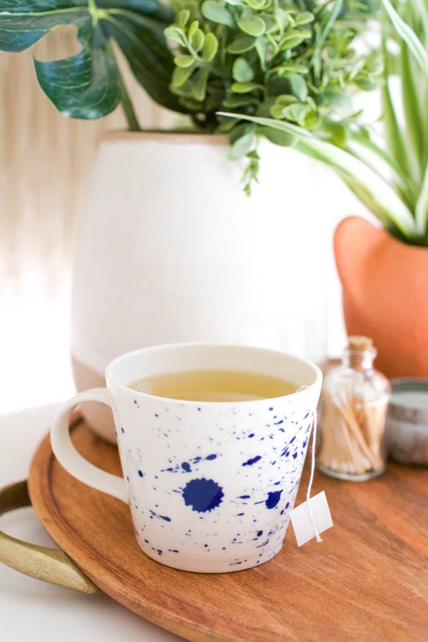 A vodka green tea hot cocktail in a mug on a table.