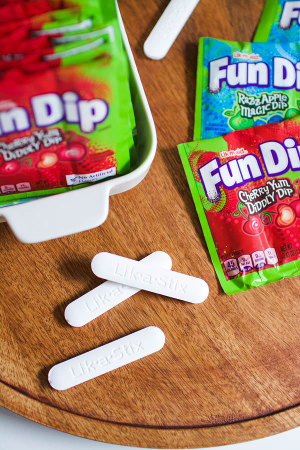 Lik a stik s from fun dip candy next to candy packages.