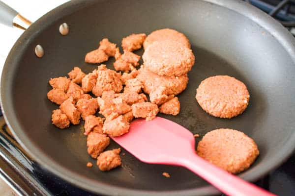 Breaking up veggie sausage patties to make a vegetarian breakfast scramble