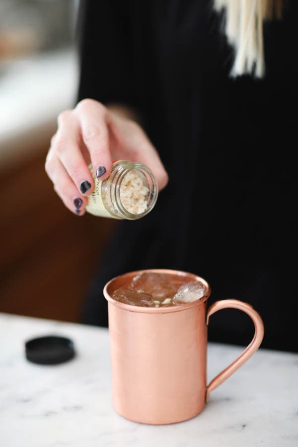 Adding garnish to a spiced pear mule.