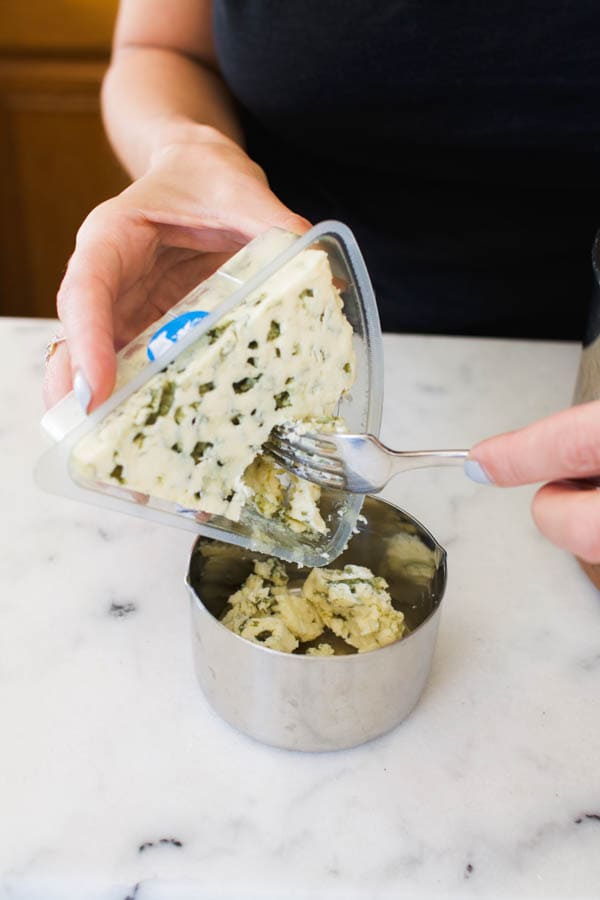 Crumble blue cheese for a sauce for potato chip nachos.