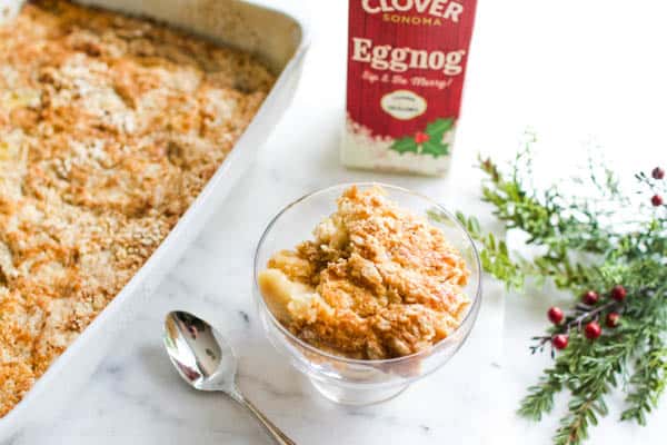 A serving of eggnog dump cake in a dish on a cutting board.