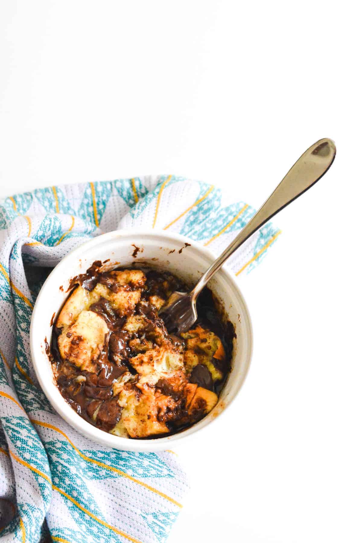 A white bowl with a Chocolate Chip Bread Pudding in it.