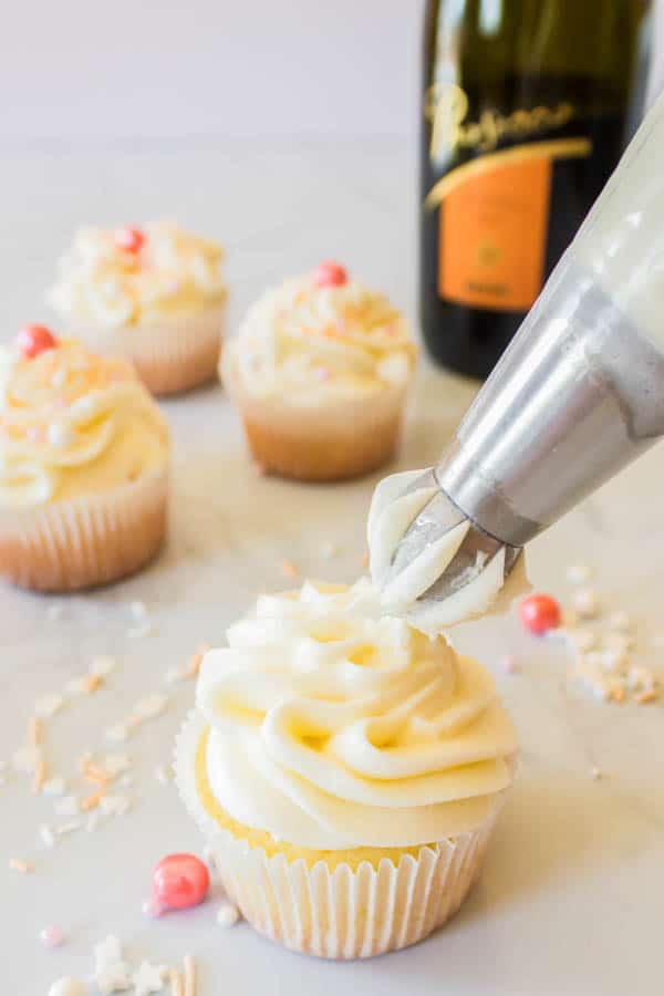 Frosting prosecco cupcakes with prosecco buttercream.