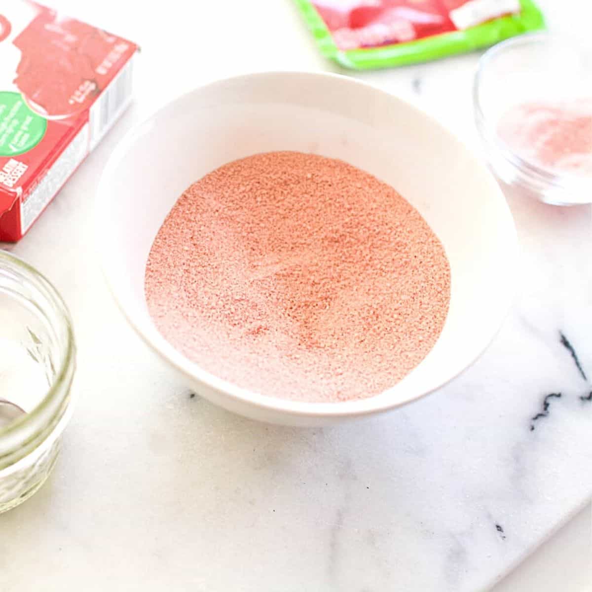 A small white bowl with pink homemade Fun Dip candy powder.