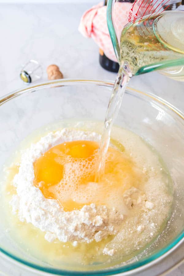 Pouring champagne into a bowl with cake batter for some boozy cupcakes. 