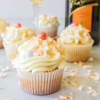 prosecco cupcakes on a table with sprinkles