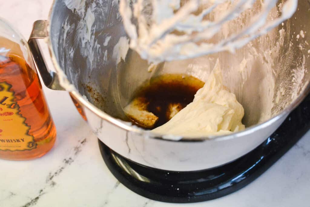 The bowl of a stand mixer with cake batter and fireball whisky.