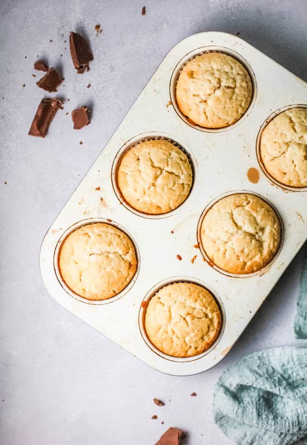 Cupcake pan with white russian cocktail cupcakes that are unfrosted on a table.