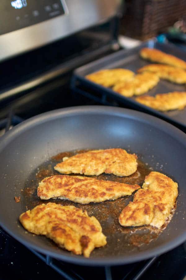 Pan frying homemade chicken tenders on the stove.