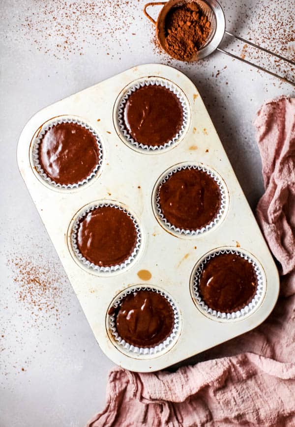 Overhead view of a cupcakes tin with chocolate batter.