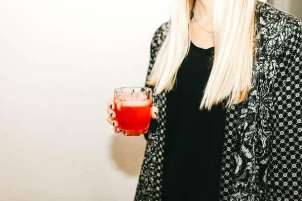 Woman holding a pink cocktail.