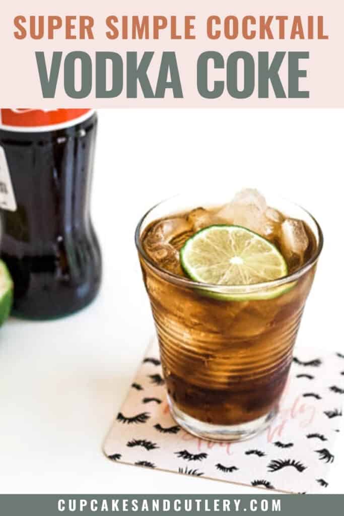 Close up of a coke in a small glass topped with lime next to a bottle of coke.