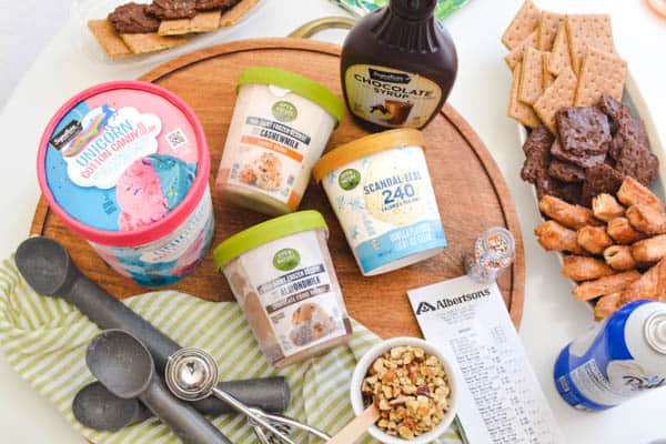 Ingredients for making an ice cream sundae laying out on a cutting board with a grocery receipt.