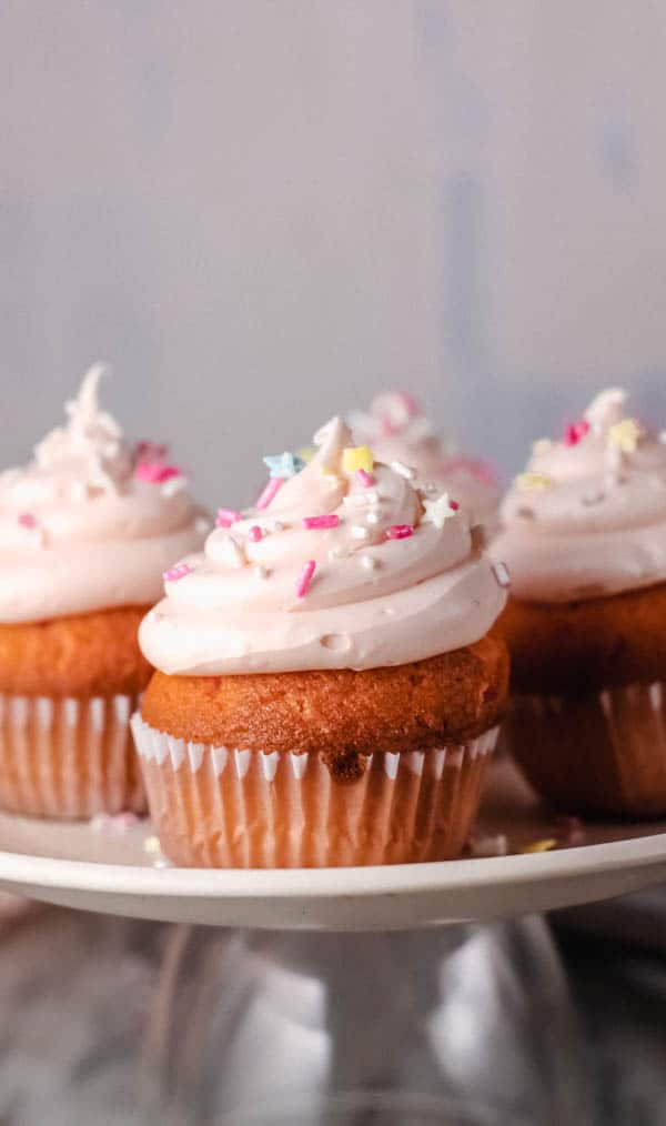 Rosé wine cupcakes on a plate with sprinkles. 