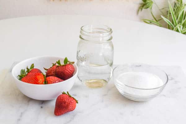 Ingredients for strawberry syrup for cocktails on a cutting board.