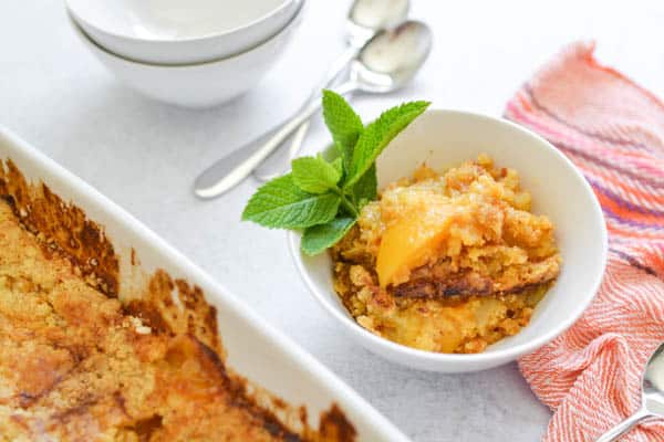 A close up of a plate of peach dump cake.