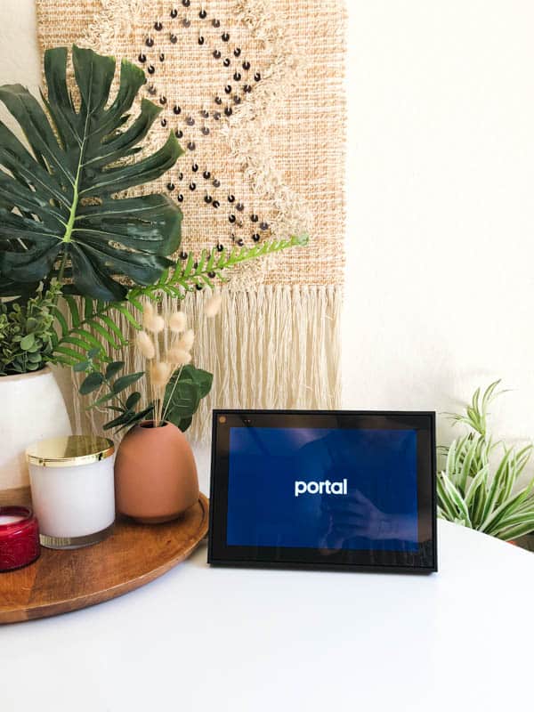 Facebook Portal on a table next to a wooden tray.