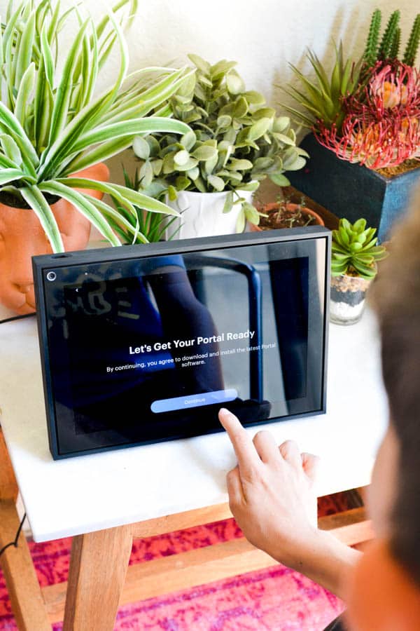 Kid setting up a Facebook portal on a table. 