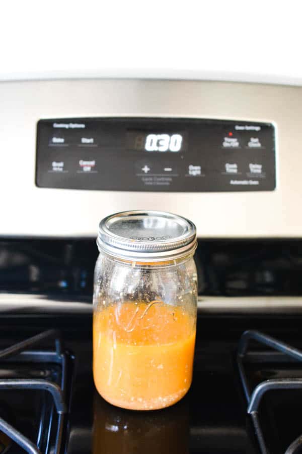 Jar of Blue Cheese Vinaigrette resting on the stovetop before serving.