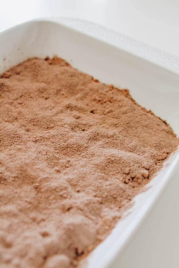 Dry chocolate cake mix in a baking dish to make a chocolate dump cake.