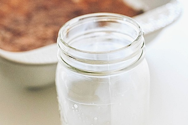 Milk in a jar next to a baking dish with ingredients for a chocolate dump cake.