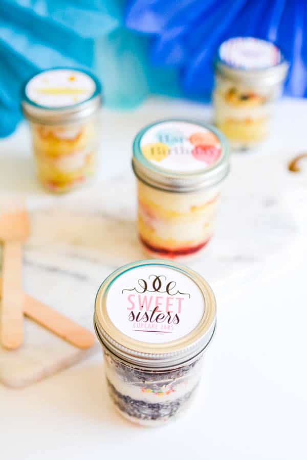 Jars of cupcakes on a table.