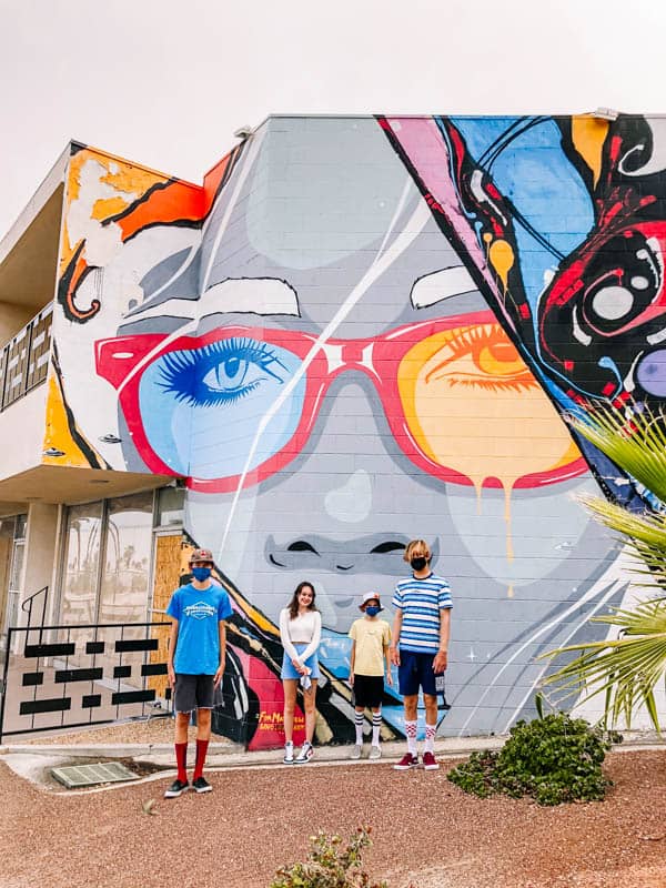 Kids in front of a colorful mural in Palm Springs. 