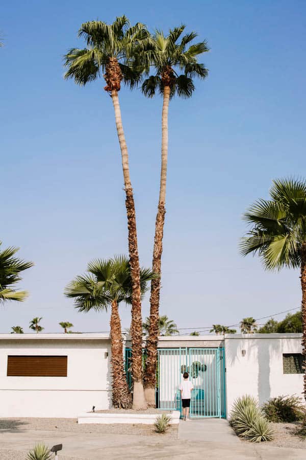 Boy at the front gate of a rental home in Palm Springs for vacation. 