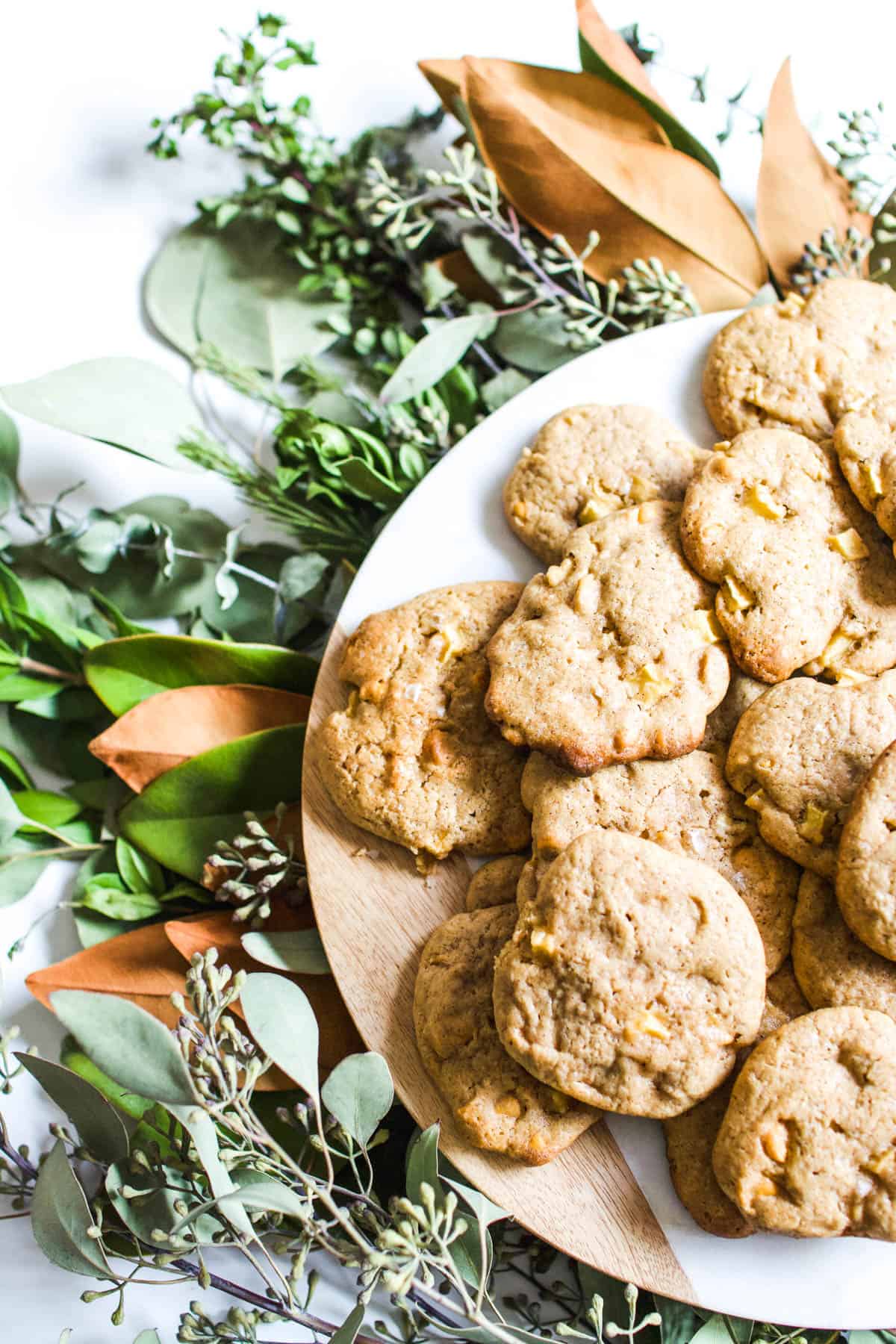 Overhead view of cookies on a platter sitting on top of fall leaves.