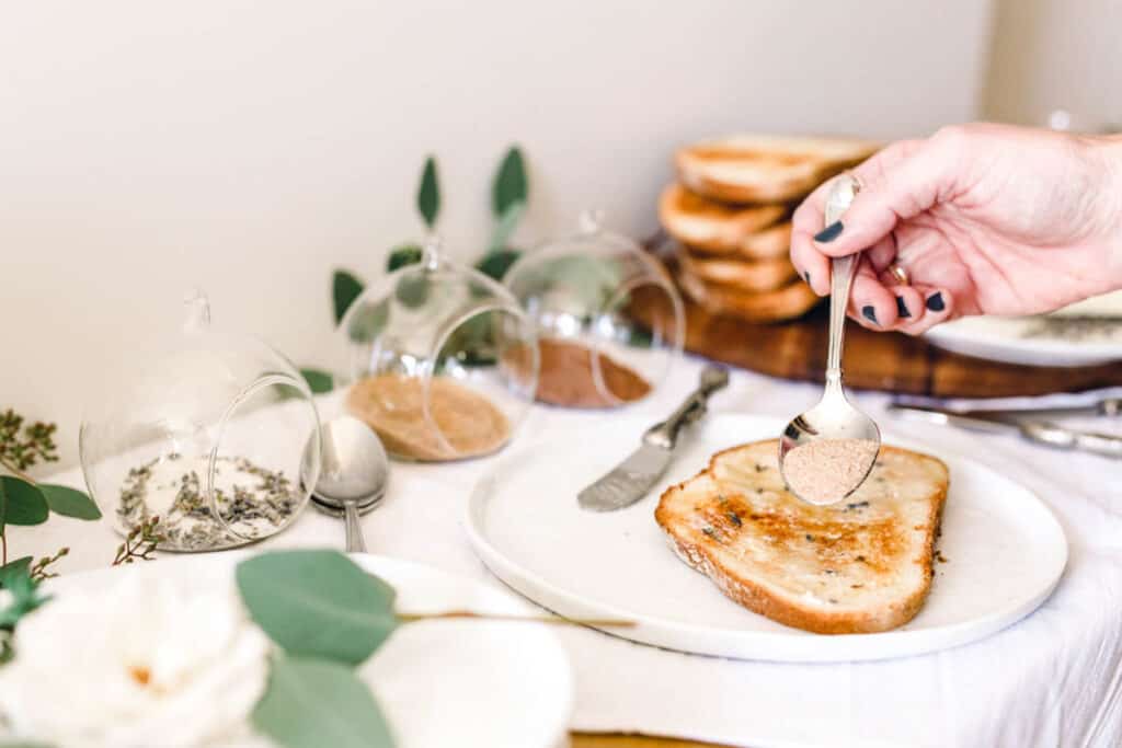 Woman sprinkling flavored sugar on a piece of toast for a christmas breakfast idea.