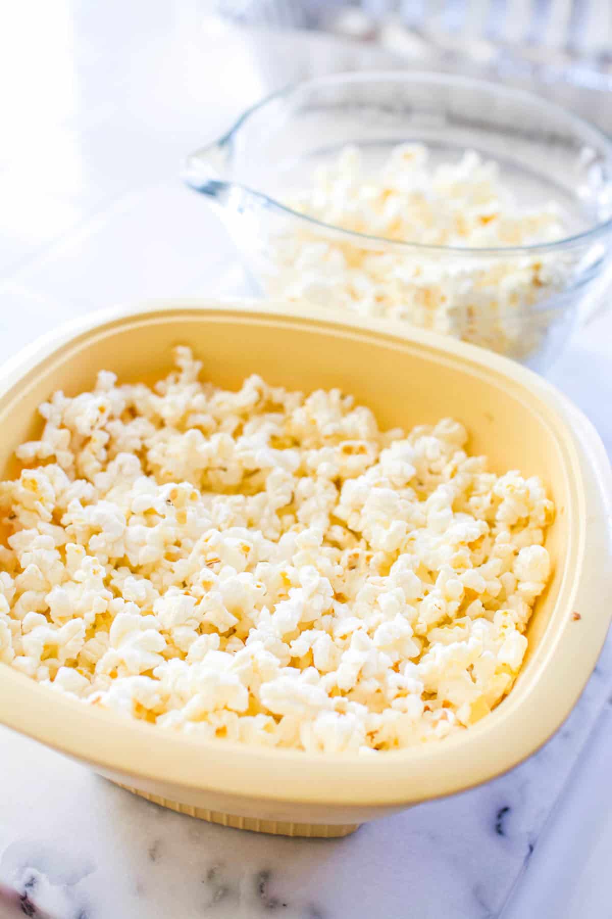 An air popper for the microwave full of popped popcorn on the counter.