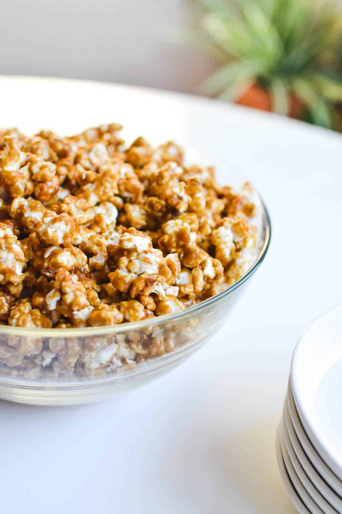 A bowl of caramel corn on a table.